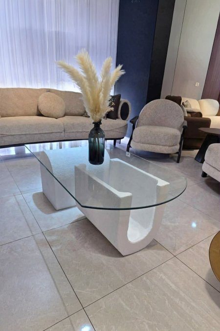 طاولة زجاجية بقاعدة حرف U حجرية