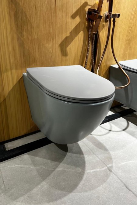 مرحاض جداري رمادي مطفأ – تصميم بيضاوي ناعم